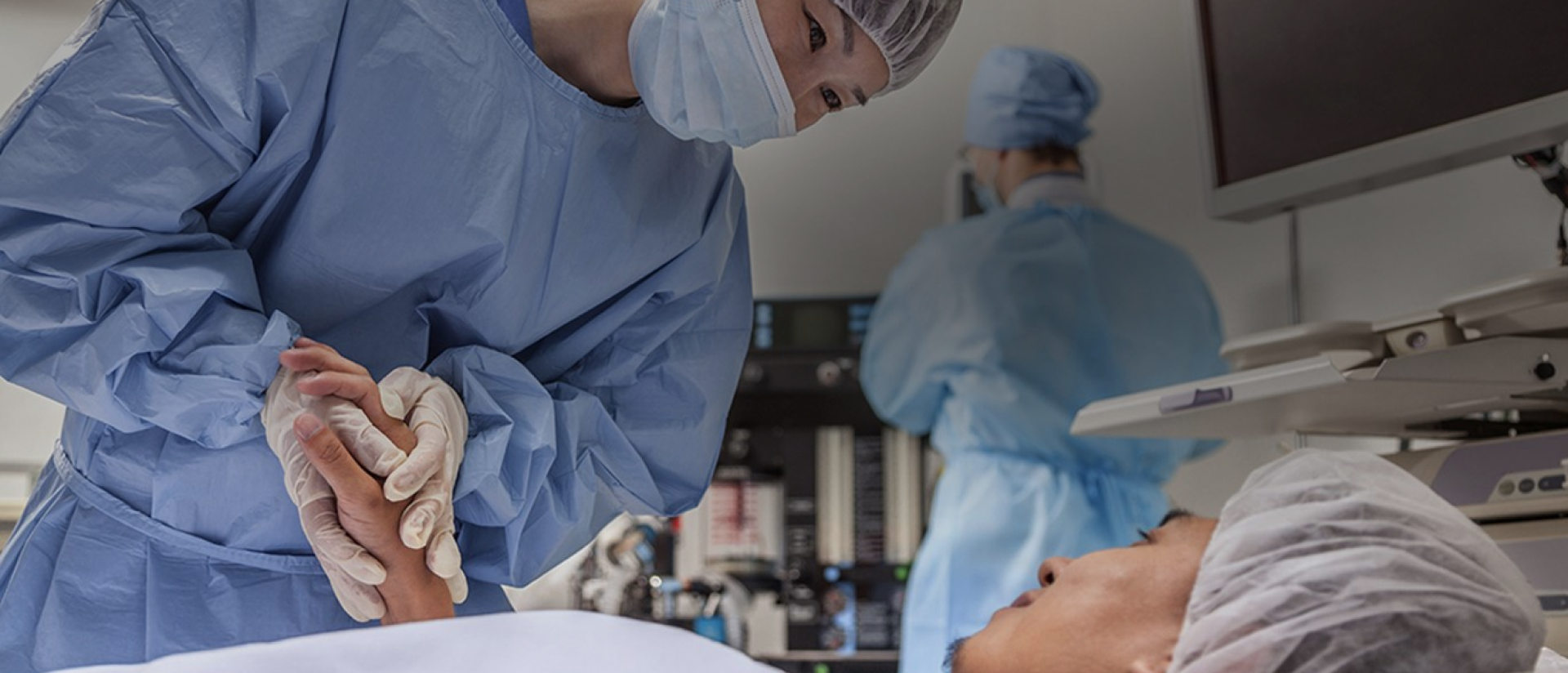 Een groep mensen in blauwe laboratoriumjassen en maskers