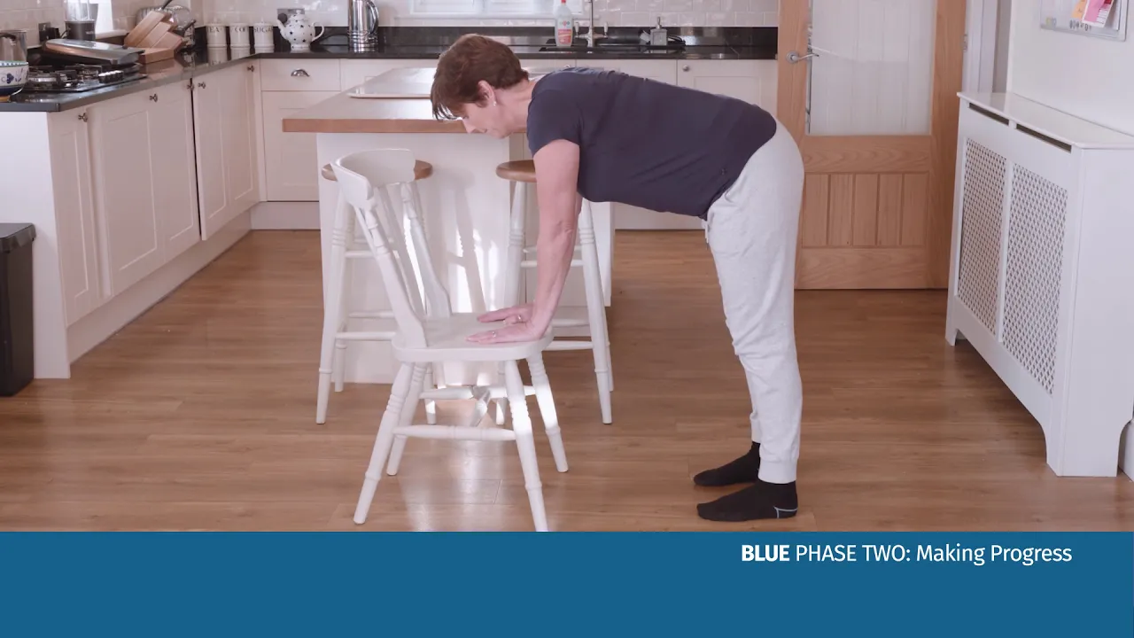 Ein Mann beugt sich über einen Stuhl